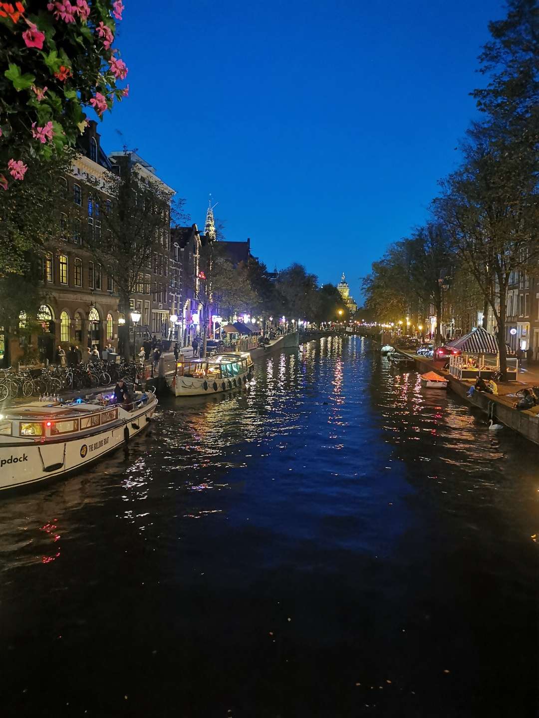 Red Light District canal at night with bridge flowers