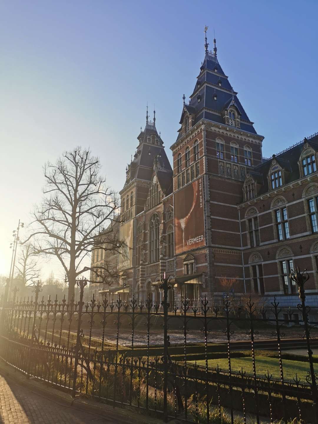 Rijksmuseum exterior with Vermeer exhibition banner in morning light