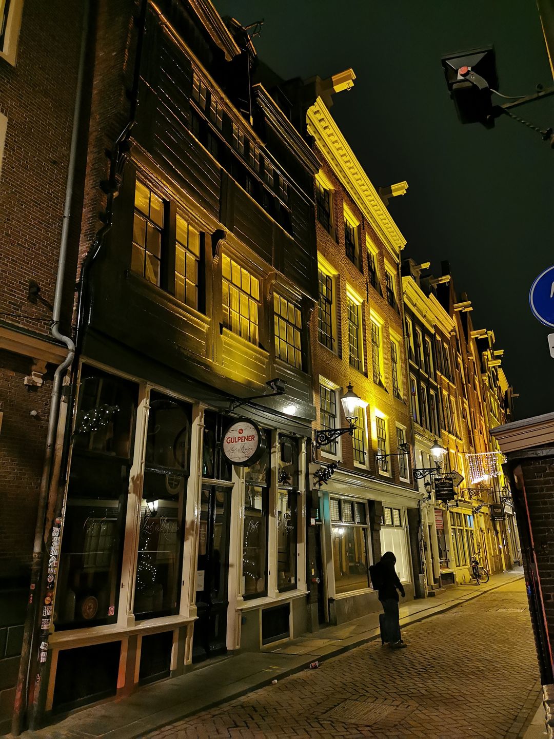 Historic Amsterdam street at night with a traditional brown cafe