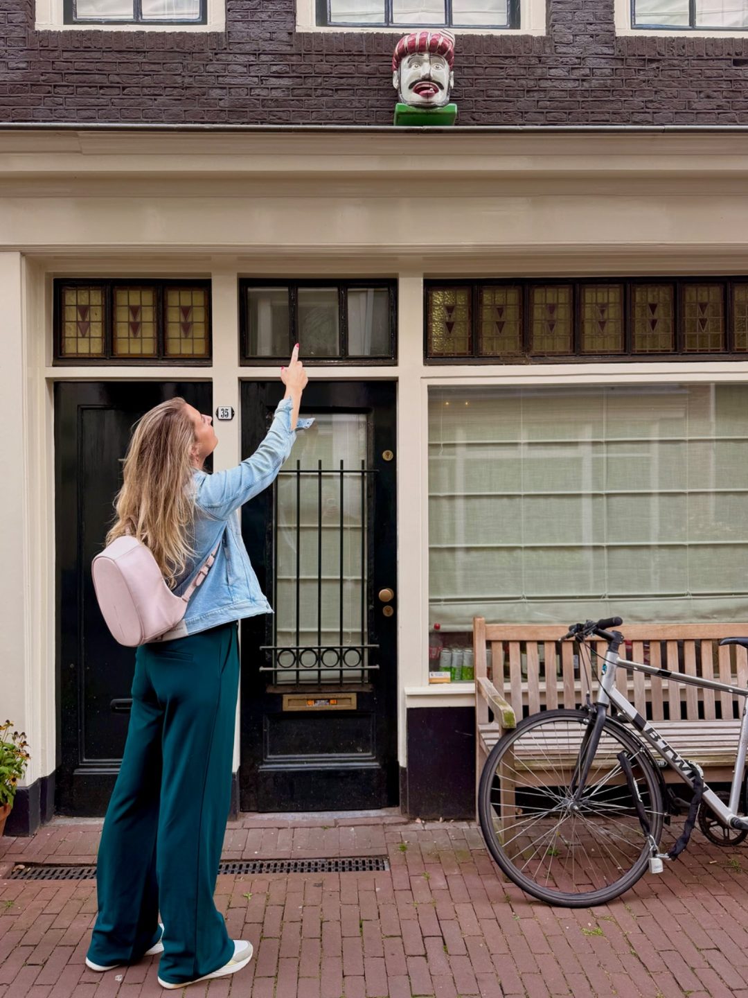 Timm pointing out a carved gable head above an Amsterdam doorway