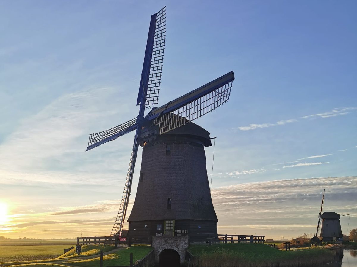 Traditional Dutch windmill at sunrise in the countryside near Amsterdam